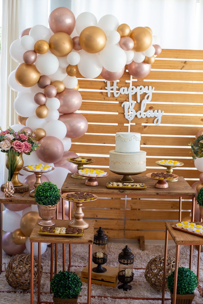 Services A beautifully decorated baby shower with balloons, dessert table, and cake.