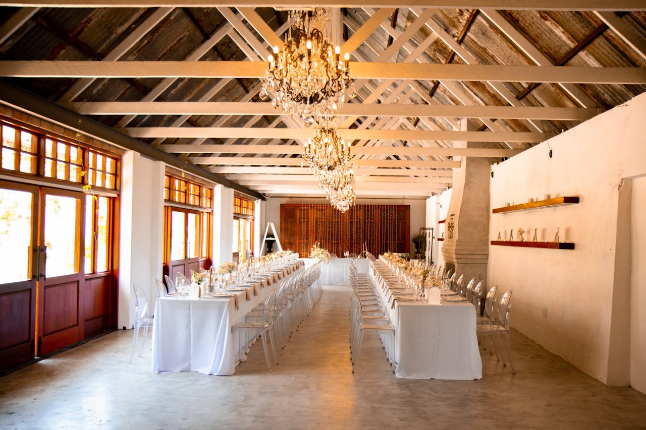 Services Luxurious wedding venue featuring crystal chandeliers and long dining tables set for an elegant reception.